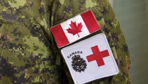 Canadian flag and medical cross patches on a military uniform